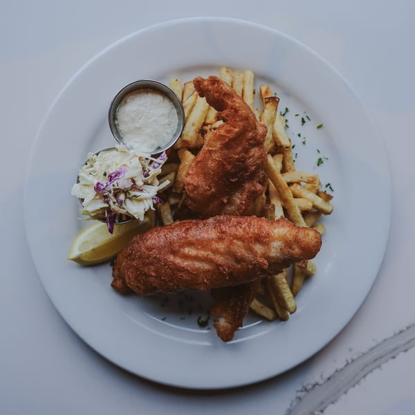 Luna & The Bear's New-American fish and chips with coleslaw, tartar sauce, and a lemon wedge.